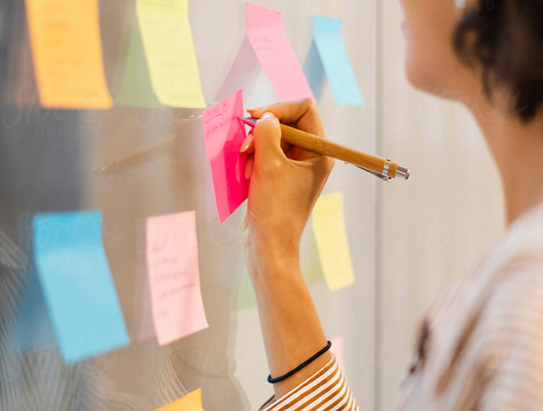 Woman writing on sticky note